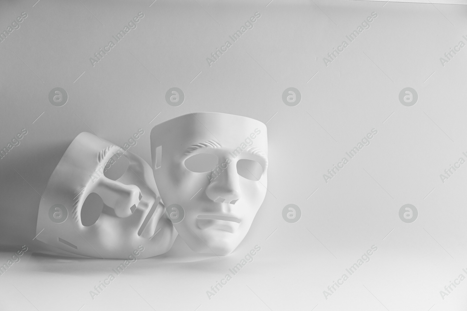 Photo of Plastic face masks on white background, space for text. Theatrical performance