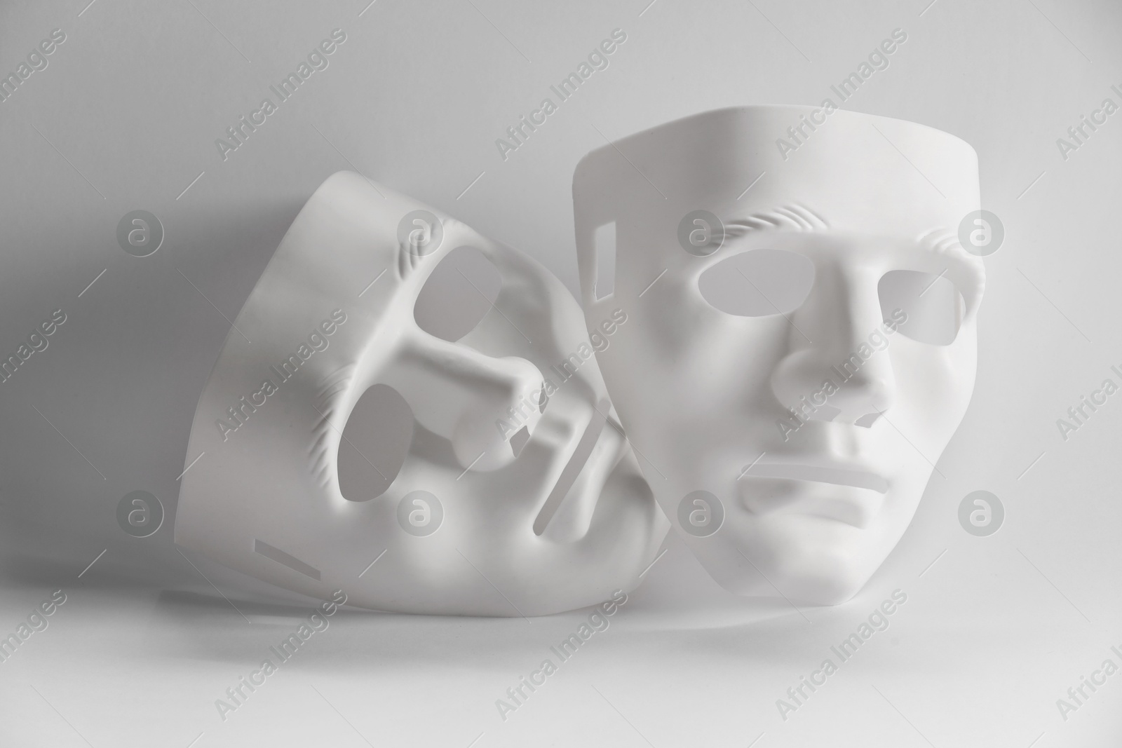 Photo of Plastic face masks on white background. Theatrical performance