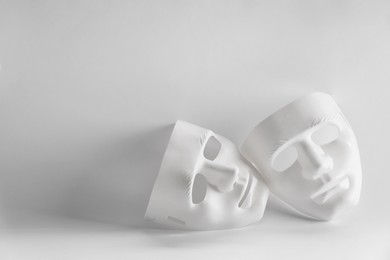 Photo of Plastic face masks on white background, space for text. Theatrical performance