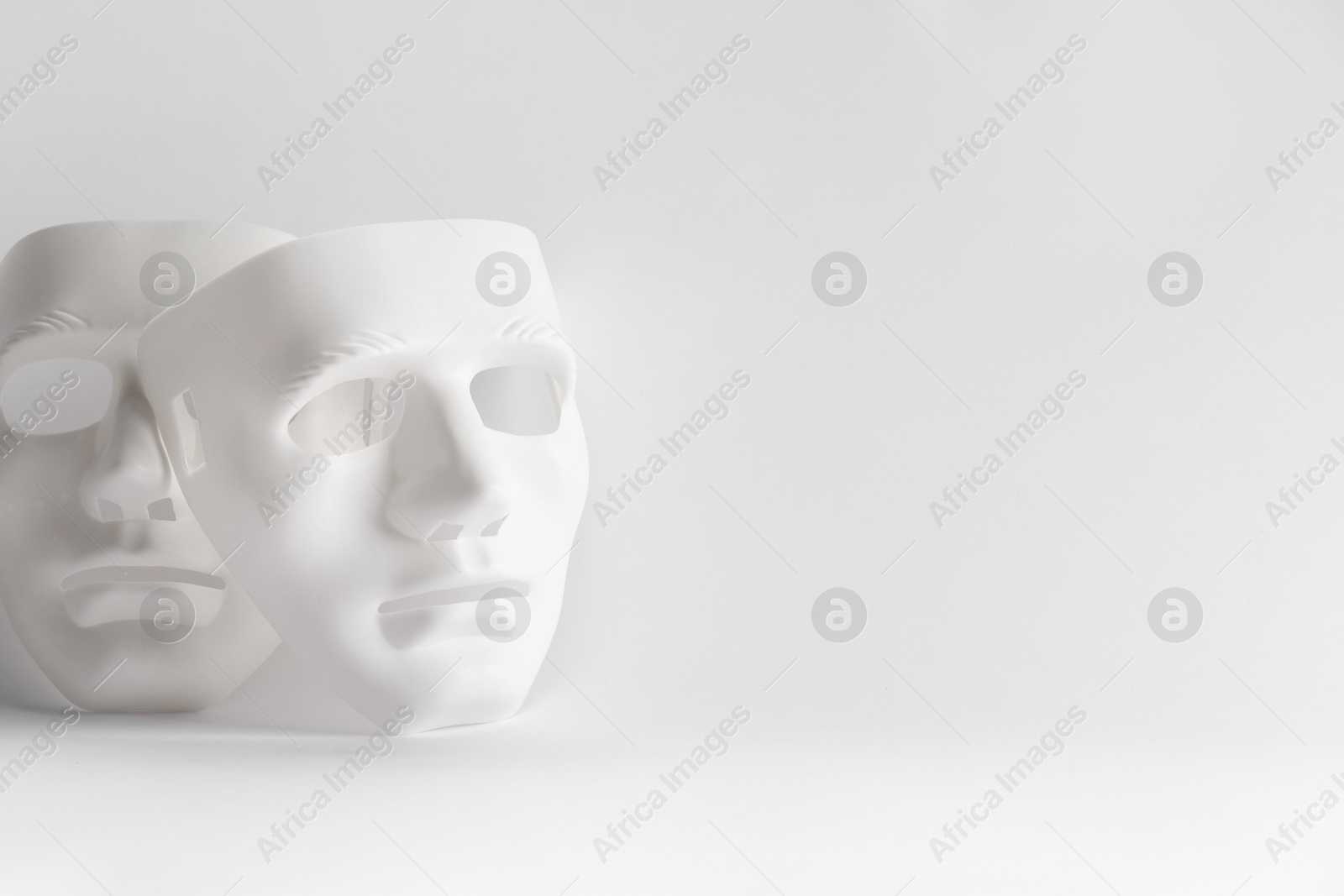 Photo of Plastic face masks on white background, space for text. Theatrical performance