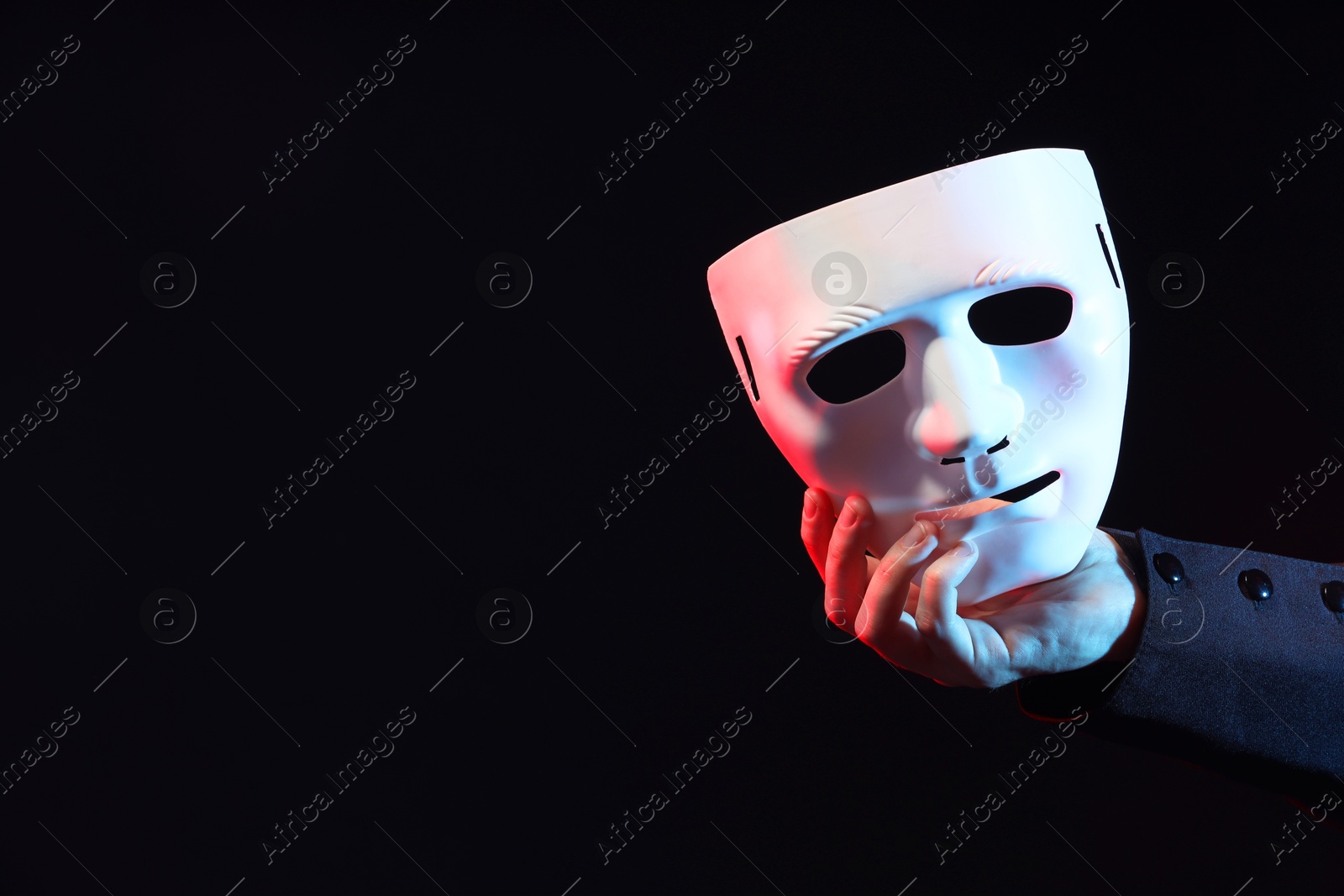 Photo of Theatrical performance. Man with plastic mask on black background, closeup. Space for text