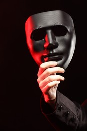 Theatrical performance. Man with plastic mask on dark background, closeup