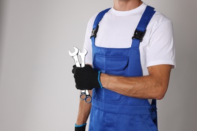 Photo of Auto mechanic with wrenches on light grey background, closeup. Space for text