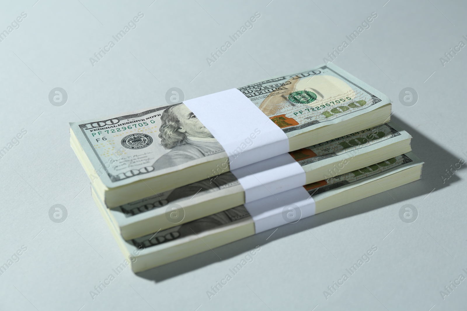 Photo of Bundles of dollar banknotes on light grey background