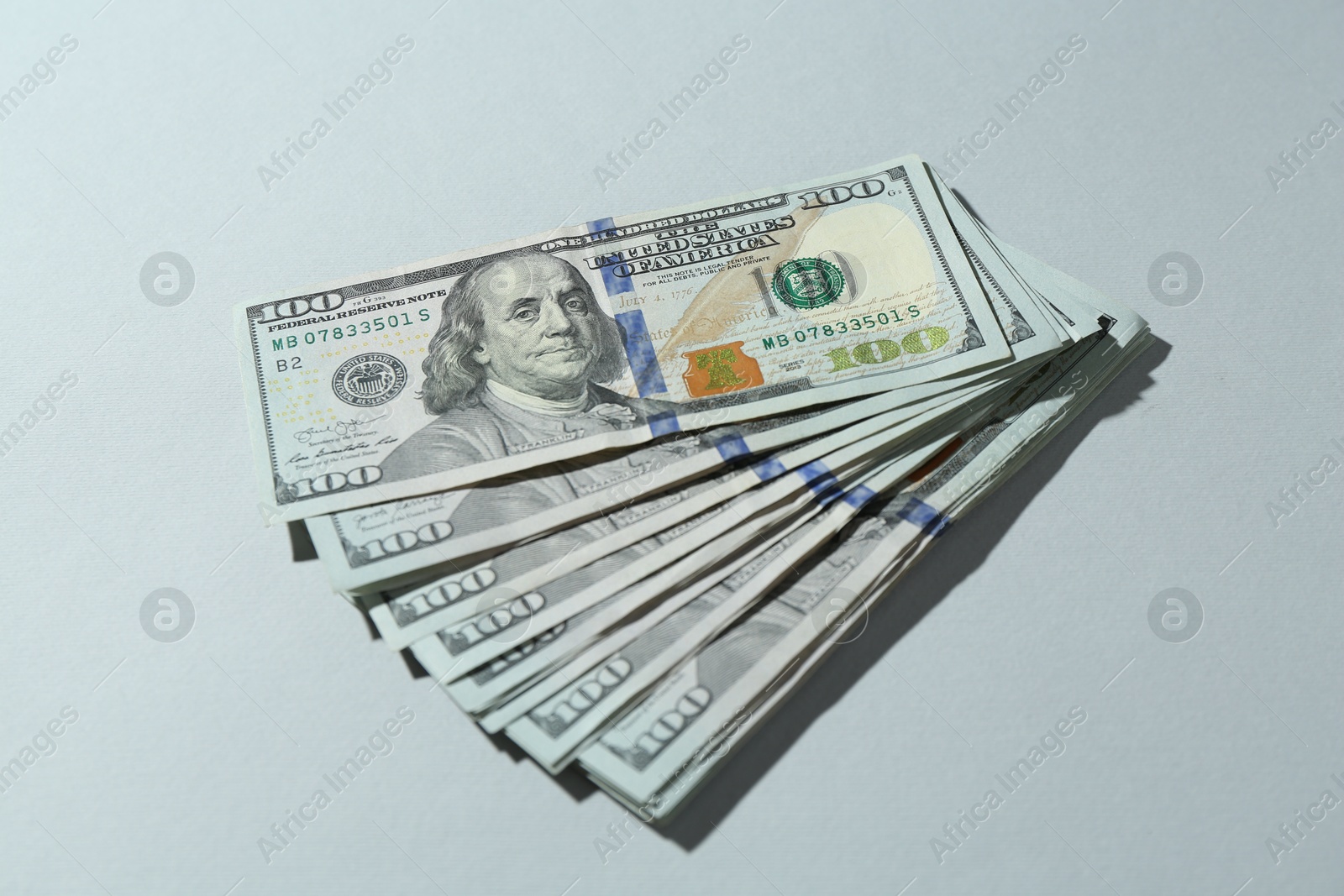 Photo of Many dollar banknotes on light grey background