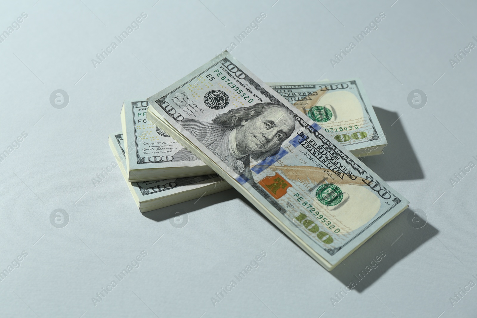 Photo of Many dollar banknotes on light grey background