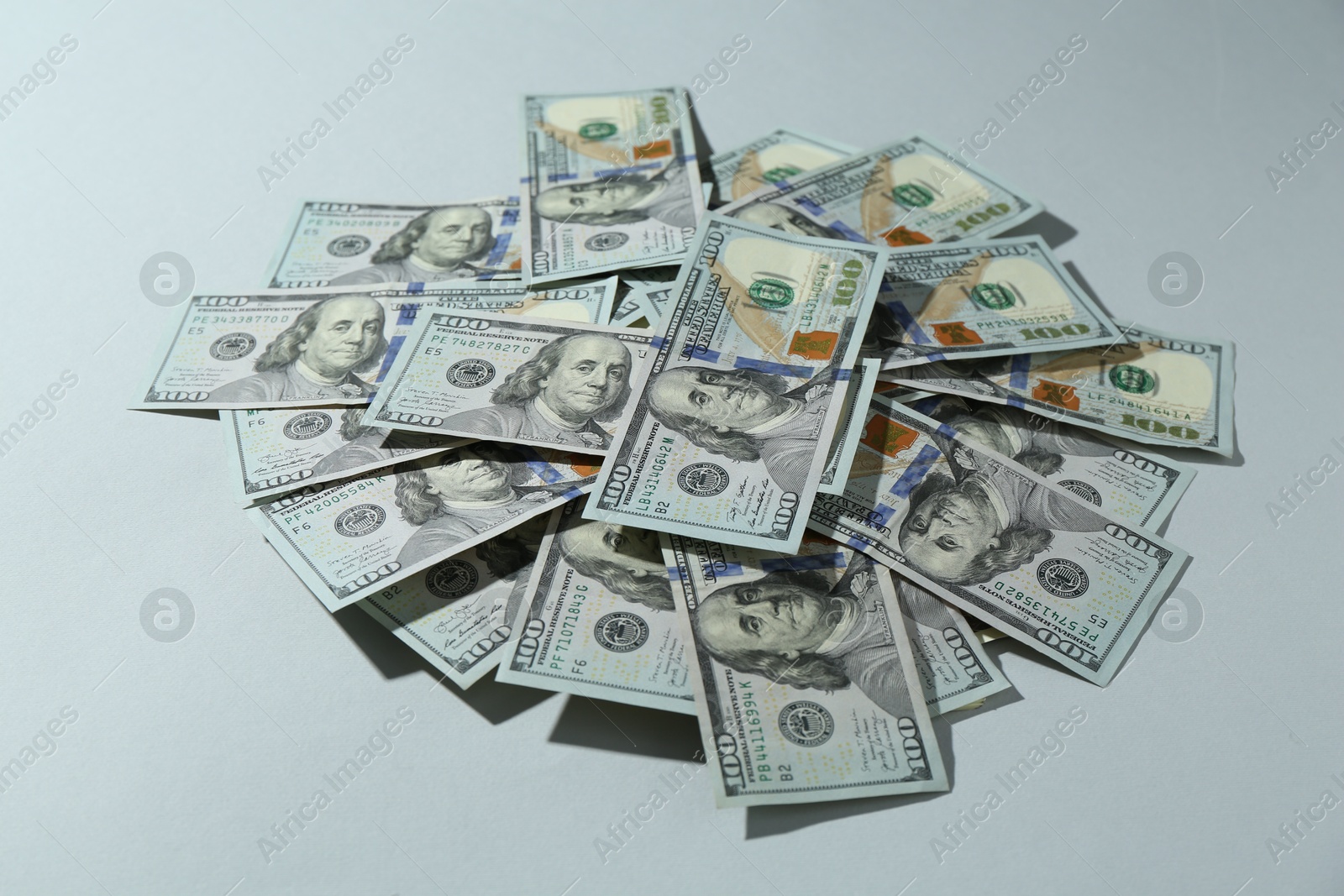 Photo of Many dollar banknotes on light grey background