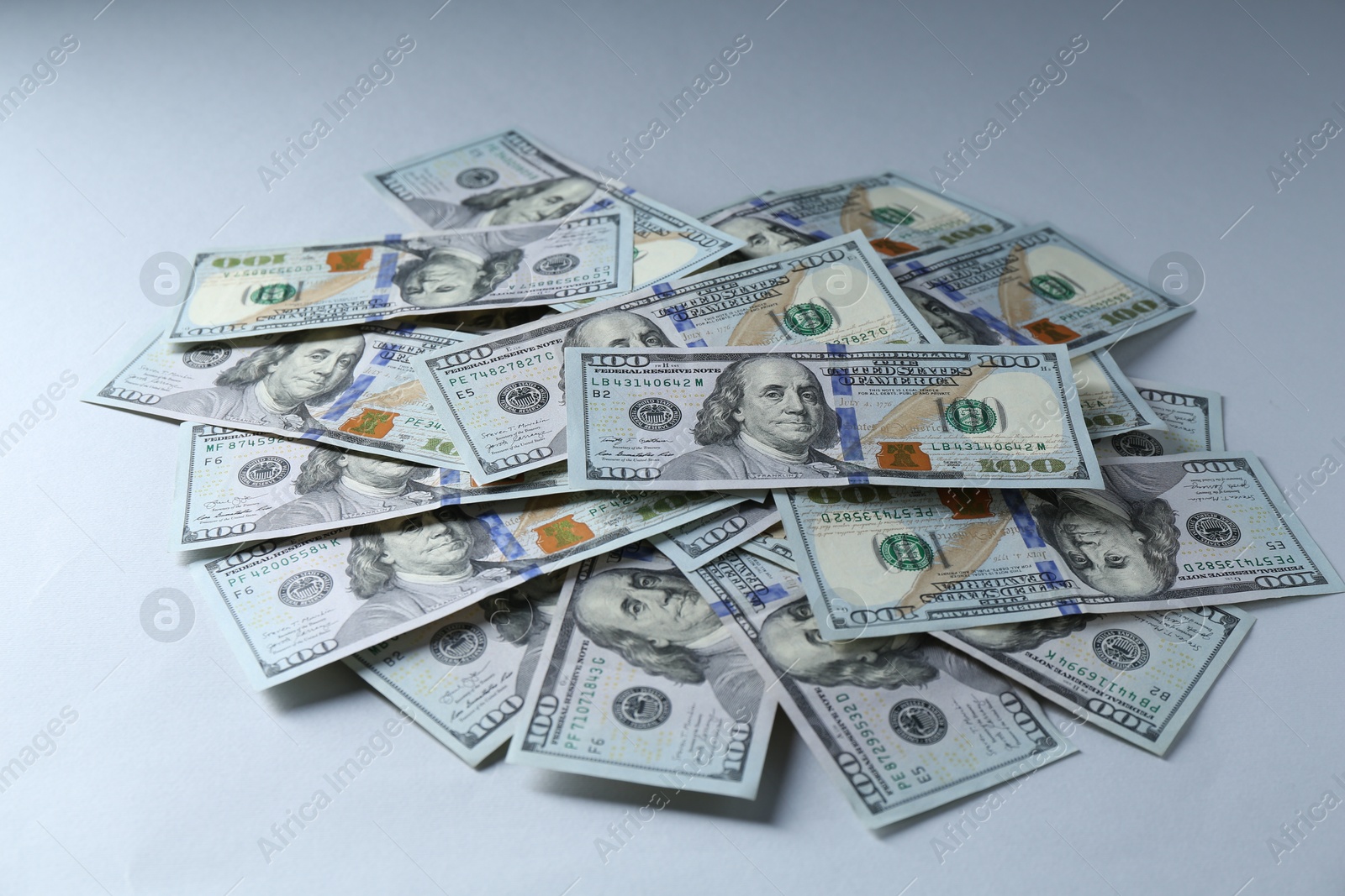 Photo of Many dollar banknotes on light grey background