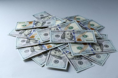 Photo of Many dollar banknotes on light grey background