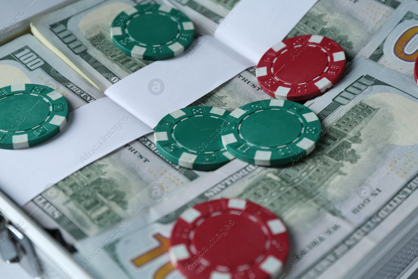 Photo of Case full of dollar banknotes and casino chips, closeup