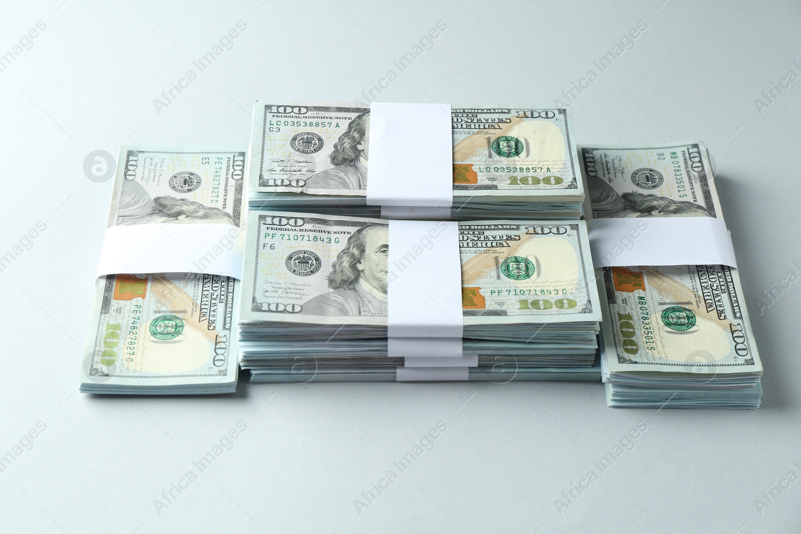 Photo of Bundles of dollar banknotes on light grey background