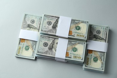 Photo of Bundles of dollar banknotes on light grey background, above view