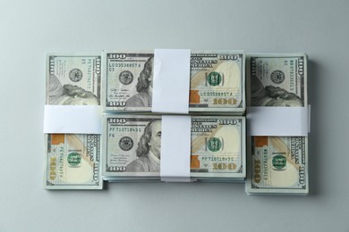 Bundles of dollar banknotes on light grey background, top view