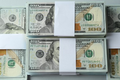 Bundles of dollar banknotes on light grey background, top view