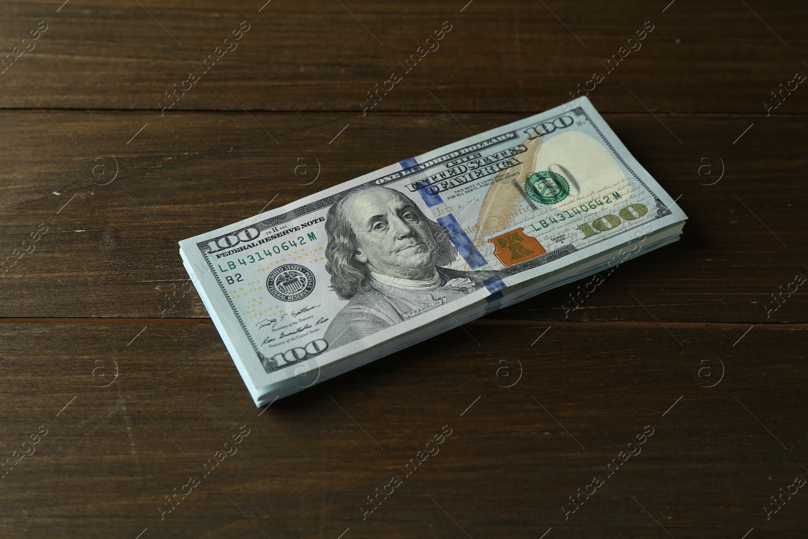 Photo of Stack of dollar banknotes on wooden table