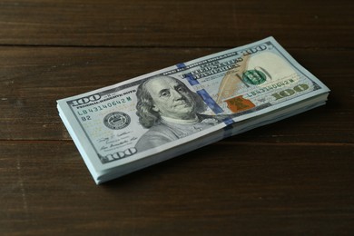 Photo of Stack of dollar banknotes on wooden table