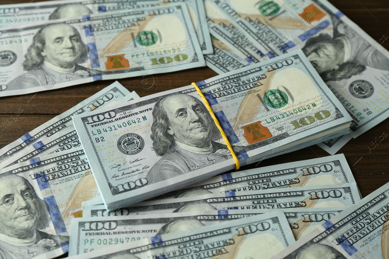 Photo of Many dollar banknotes on wooden table. American currency