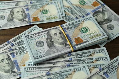 Many dollar banknotes on wooden table. American currency