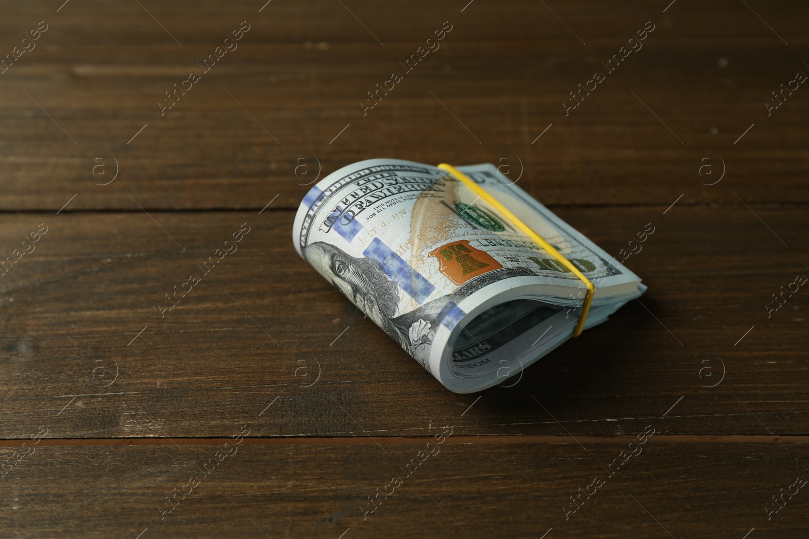 Photo of Bundle of dollar banknotes on wooden table