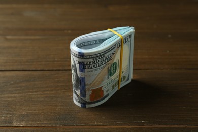 Photo of Bundle of dollar banknotes on wooden table