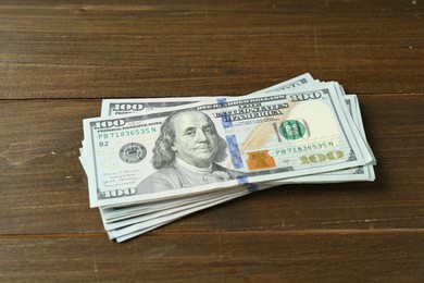 Many dollar banknotes on wooden table. American currency