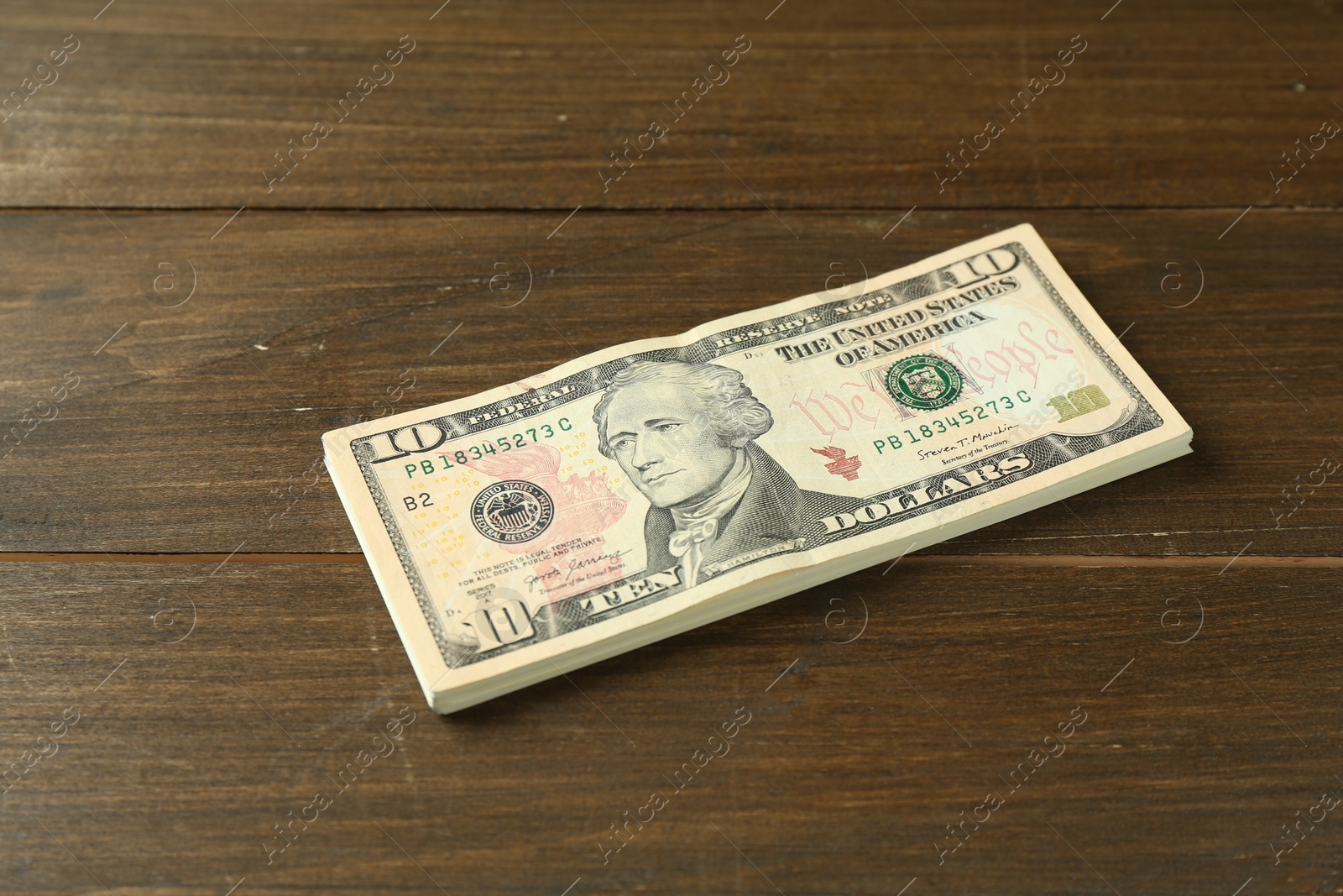 Photo of Stack of dollar banknotes on wooden table