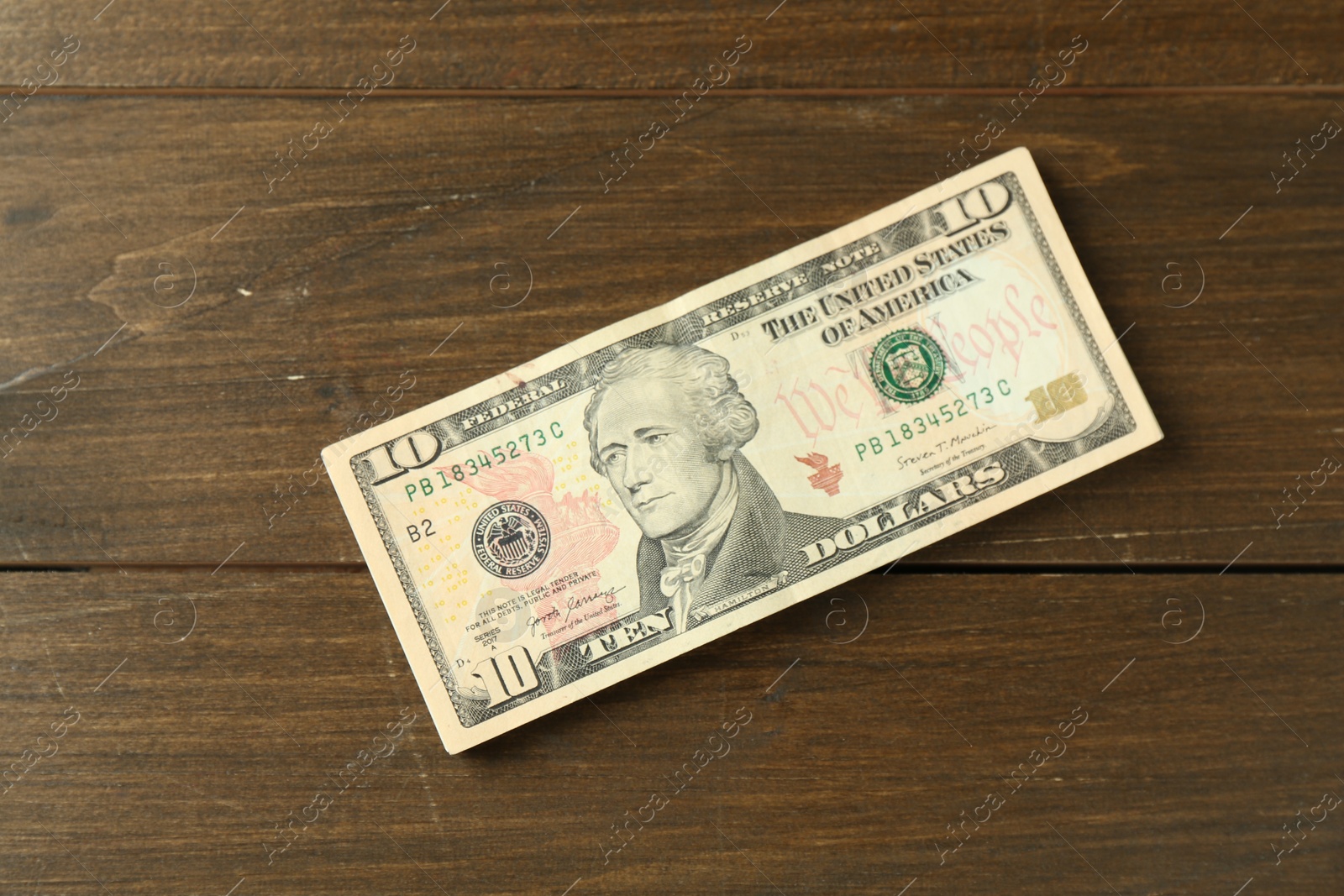 Photo of Stack of dollar banknotes on wooden table, top view