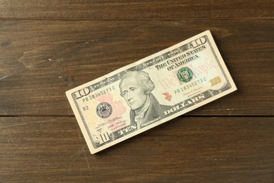 Photo of Stack of dollar banknotes on wooden table, top view