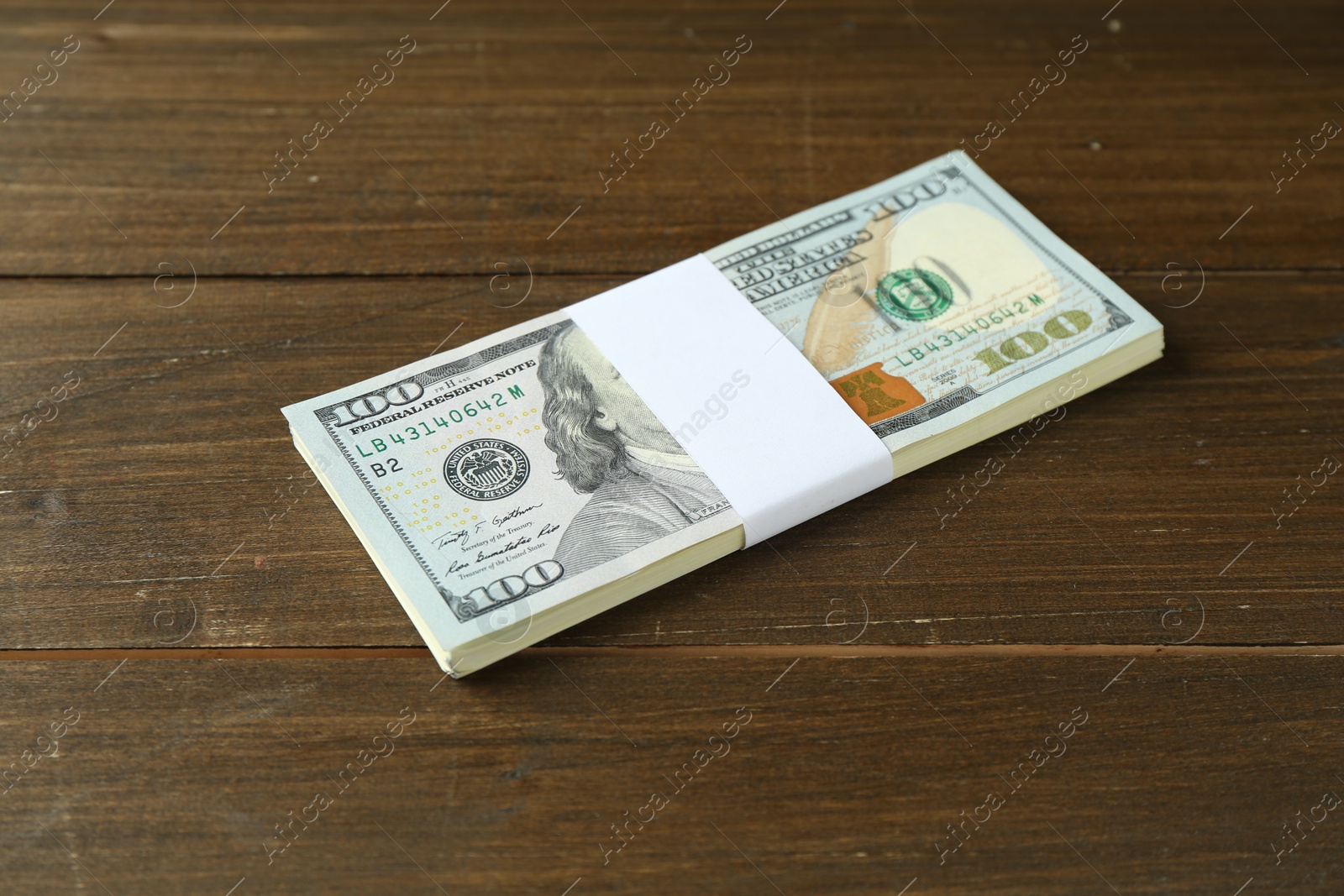 Photo of Bundle of dollar banknotes on wooden table