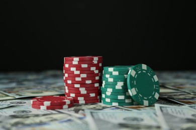 Many dollar banknotes and casino chips on black background