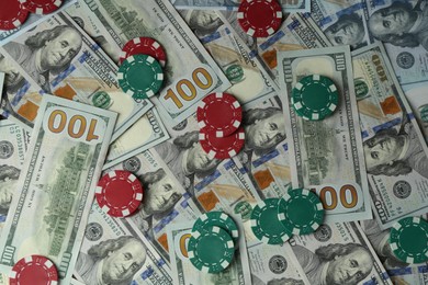 Photo of Many dollar banknotes and casino chips as background, top view