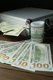 Metal cases full with dollar banknotes on wooden table, closeup