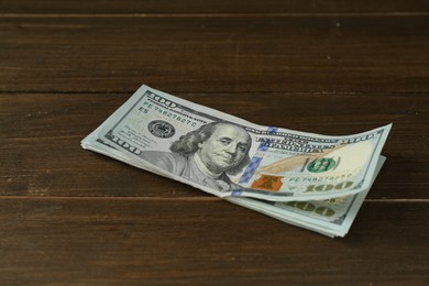 Photo of Many dollar banknotes on wooden table. American currency