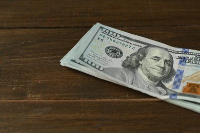 Photo of Many dollar banknotes on wooden table, closeup