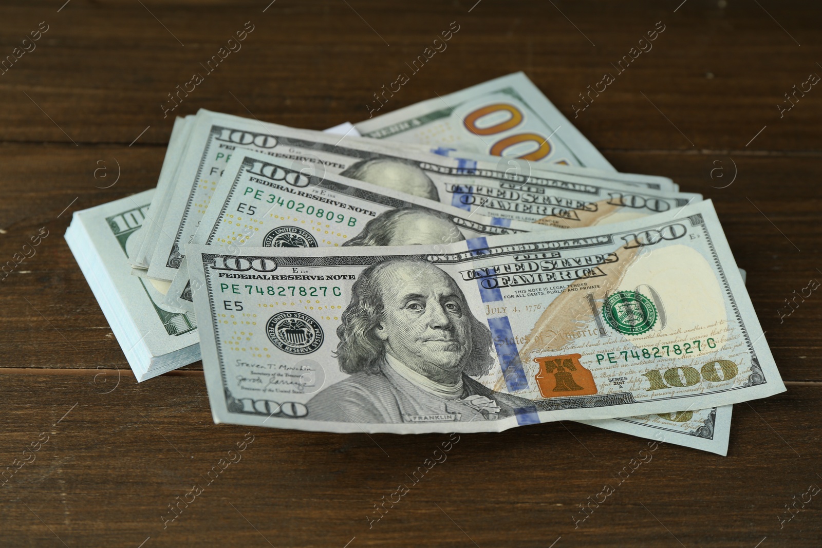 Photo of Many dollar banknotes on wooden table. American currency