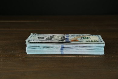 Photo of Stack of dollar banknotes on wooden table