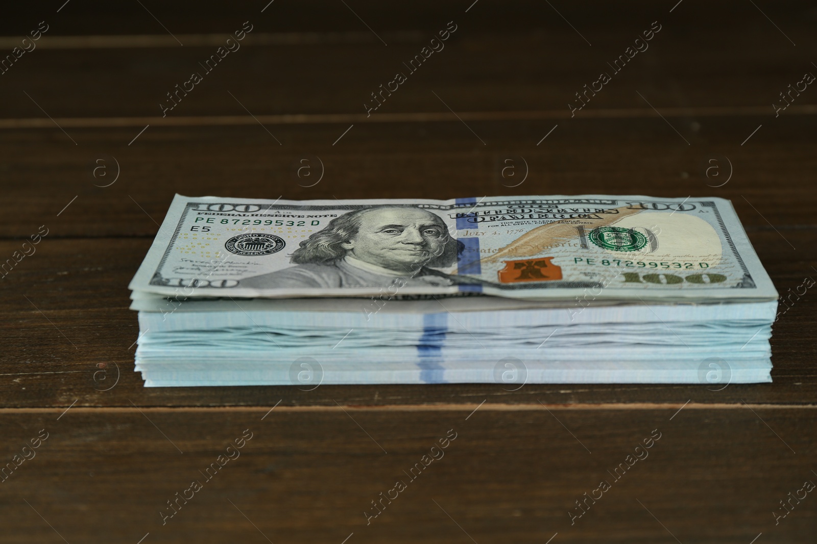 Photo of Stack of dollar banknotes on wooden table