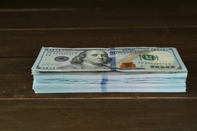 Photo of Stack of dollar banknotes on wooden table