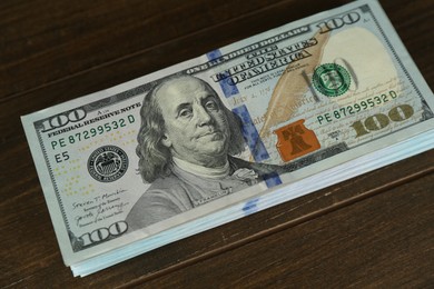 Stack of dollar banknotes on wooden table, closeup