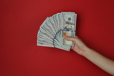 Woman with dollar banknotes on red background, closeup