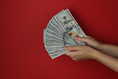 Photo of Woman with dollar banknotes on red background, closeup. Space for text