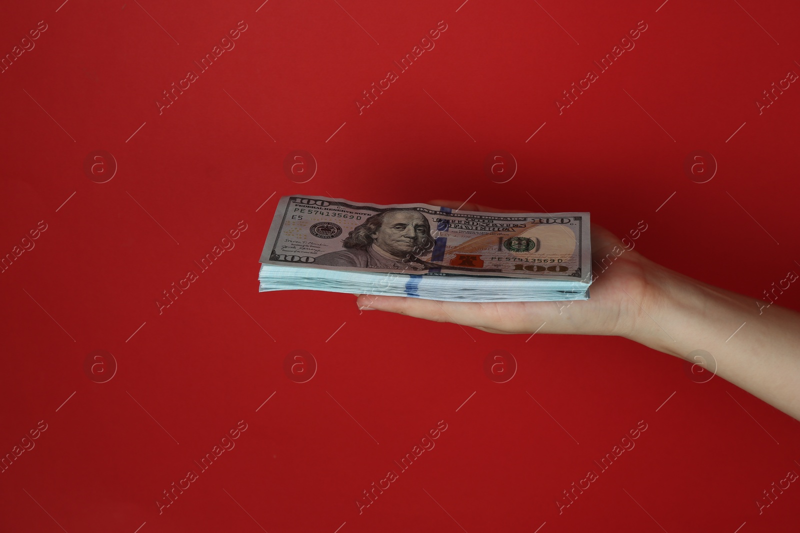 Photo of Woman with dollar banknotes on red background, closeup