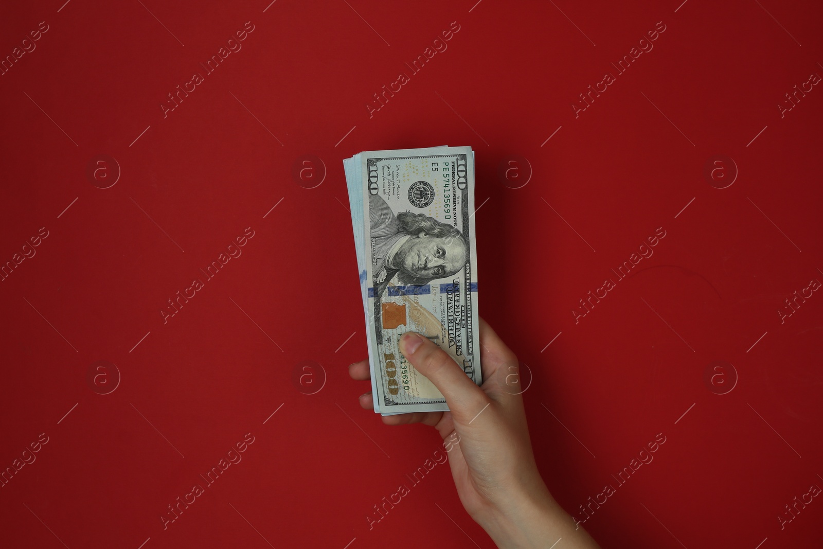 Photo of Woman with dollar banknotes on red background, closeup