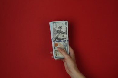 Photo of Woman with dollar banknotes on red background, closeup