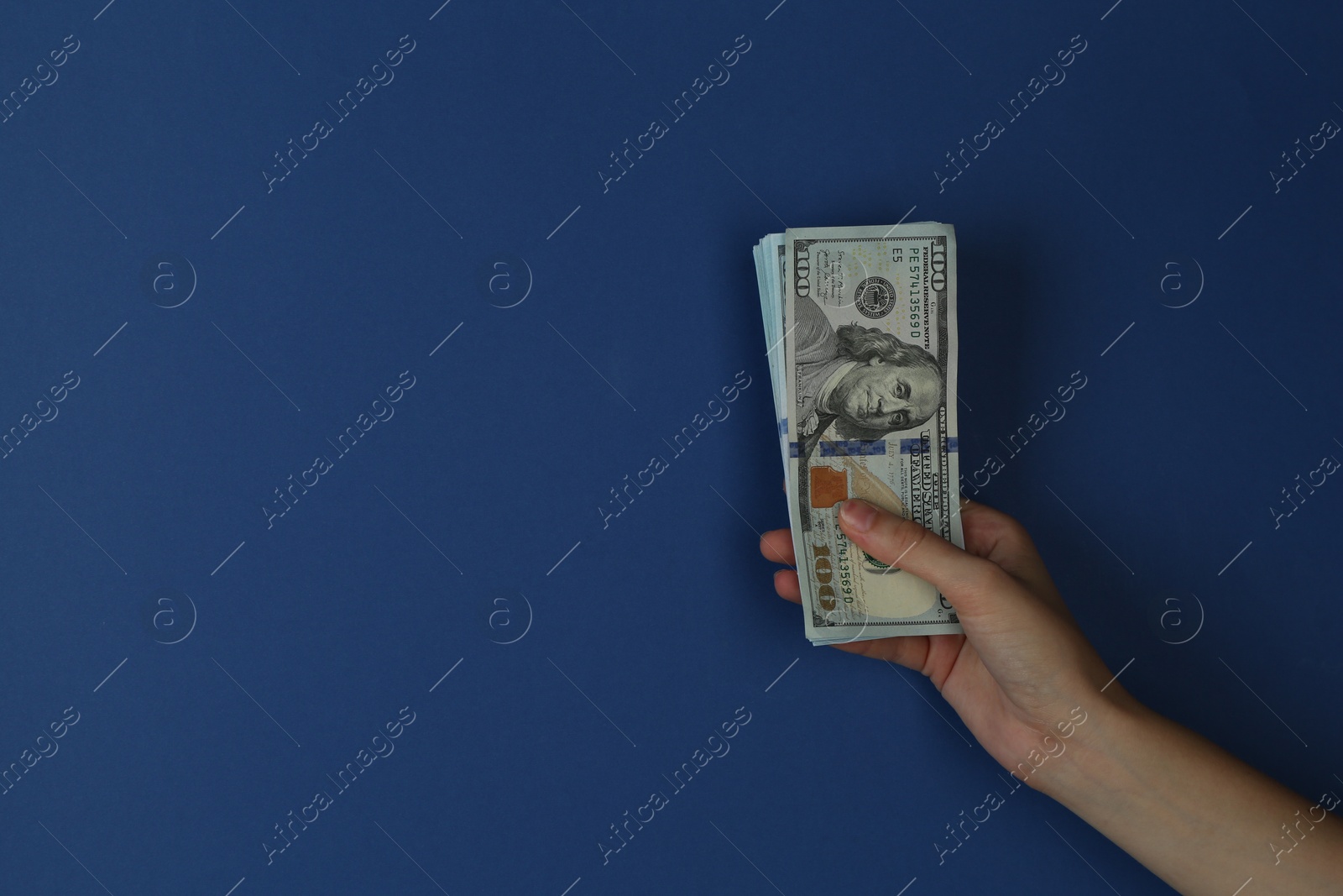 Photo of Woman with dollar banknotes on blue background, closeup. Space for text