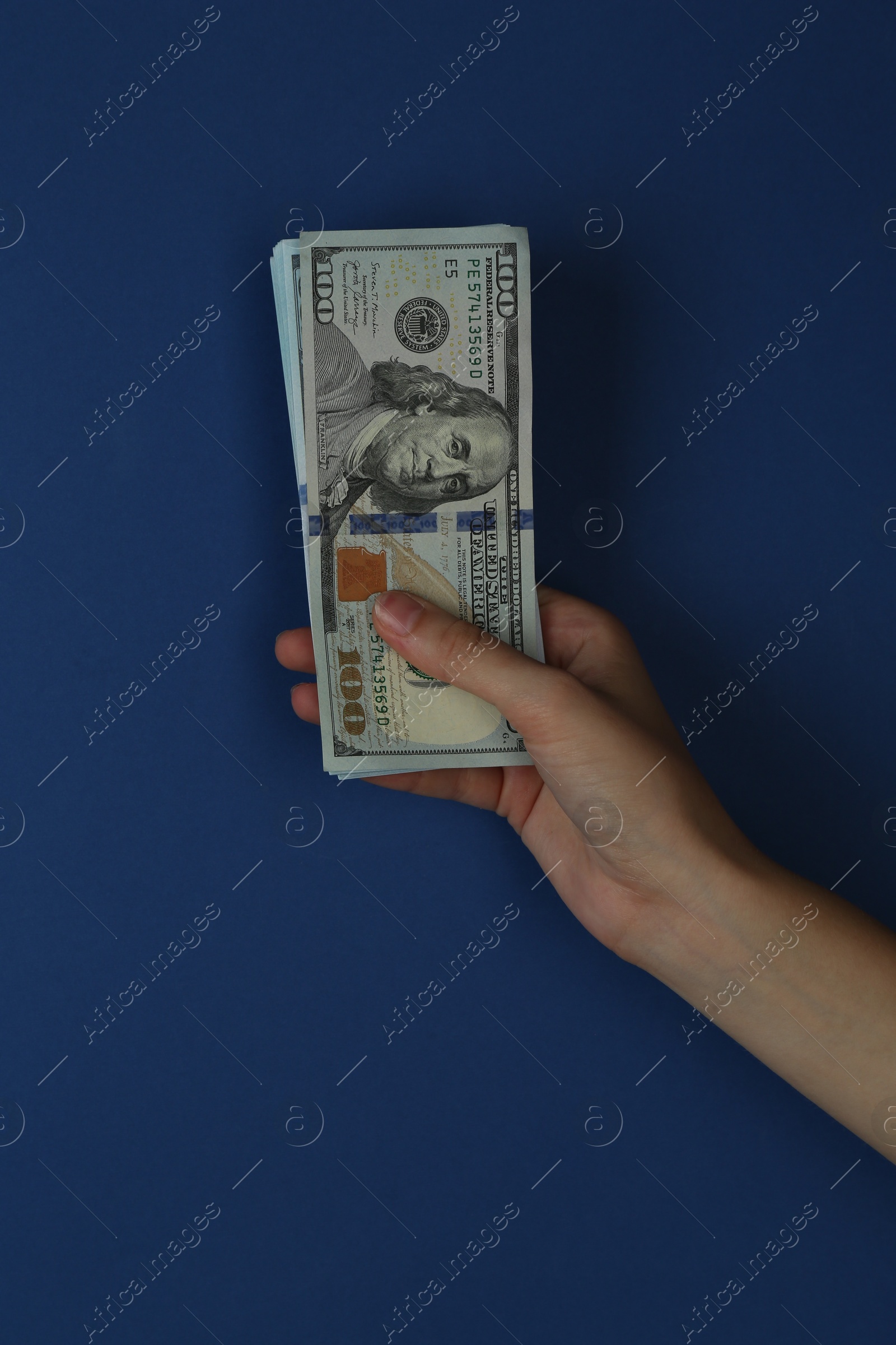 Photo of Woman with dollar banknotes on blue background, closeup