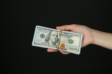 Woman with dollar banknotes on black background, closeup