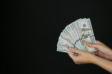 Photo of Woman with dollar banknotes on black background, closeup. Space for text