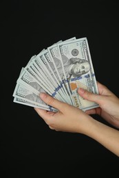 Woman with dollar banknotes on black background, closeup