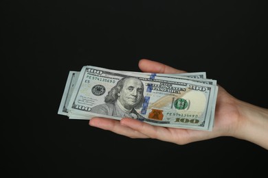 Woman with dollar banknotes on black background, closeup